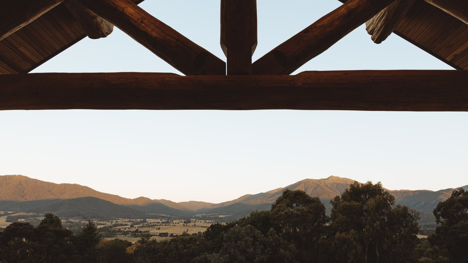 Mountain view framed by log beams