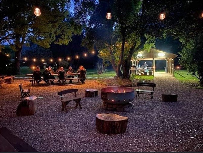 The firepit at night with fairy lights in the trees