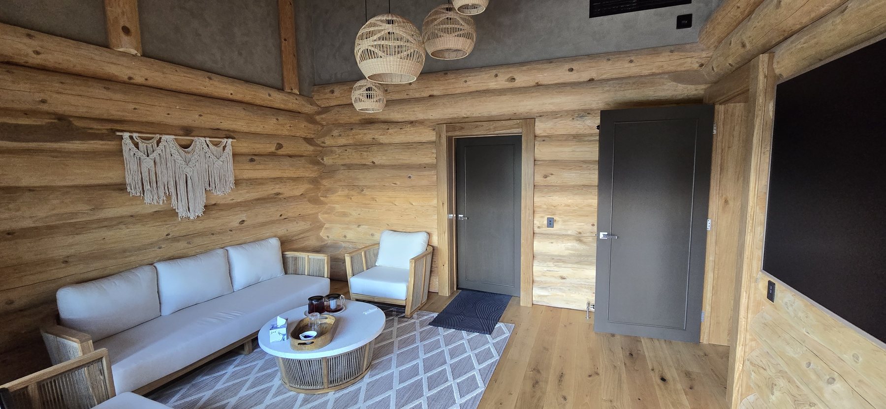 The relaxation lounge: log walls, sofa and pendant lamps