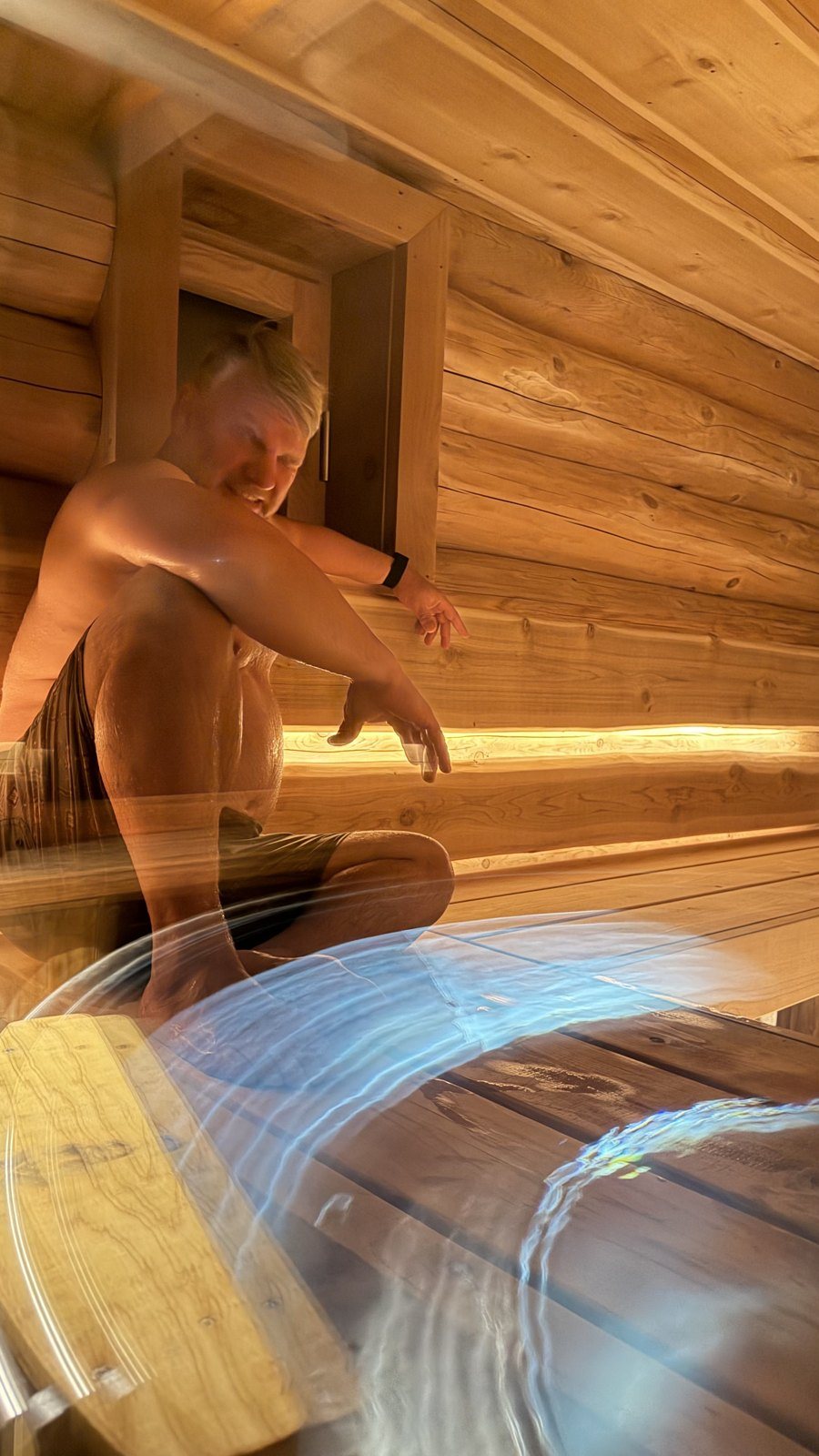 Steam master Sandris throwing water on the cedar benches of the Log Banya sauna, Mount Beauty