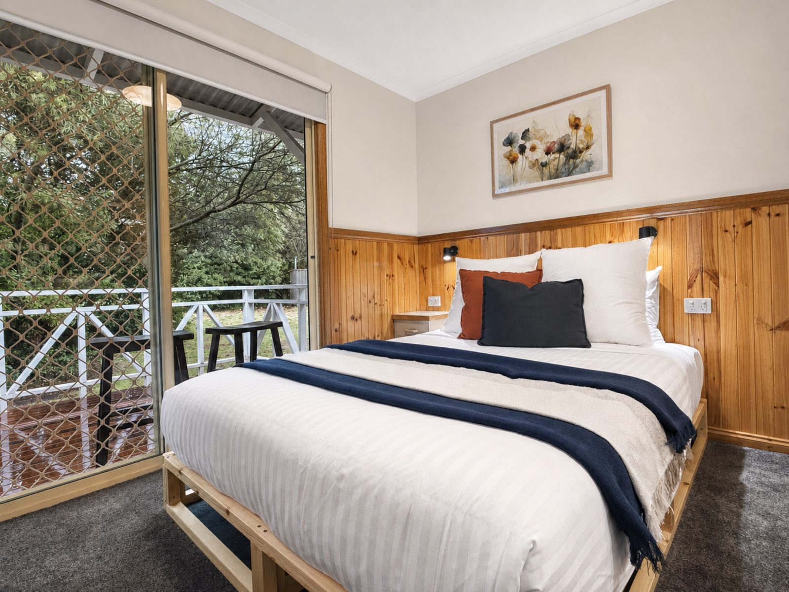 The Cabin's queen bedroom, Bright, with the deck outside the window